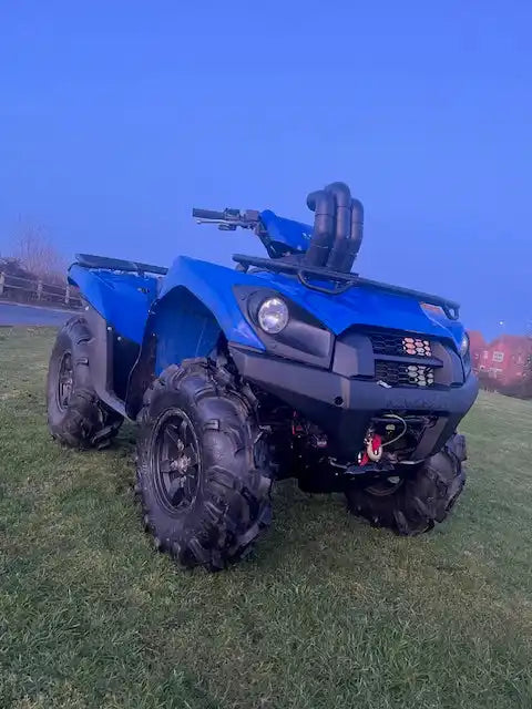 Blue all-terrain vehicle (ATV) with large, aggressive off-road tires and a snorkel kit.