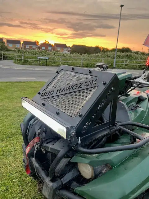 Green ATV with a custom black radiator cover and an LED light bar.