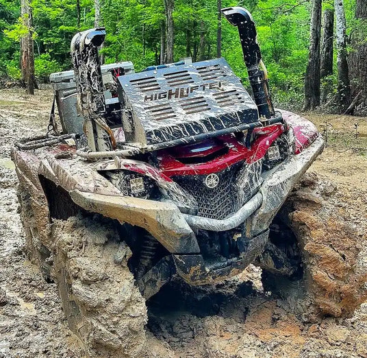 Mud-covered red and gray all-terrain vehicle.