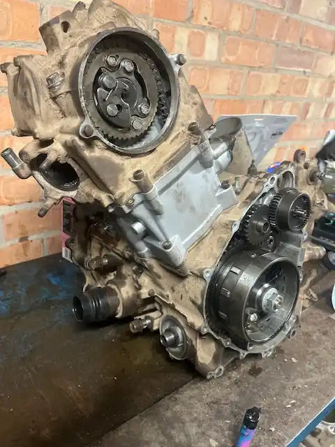 A partially disassembled internal combustion engine, showing gears and internal components.